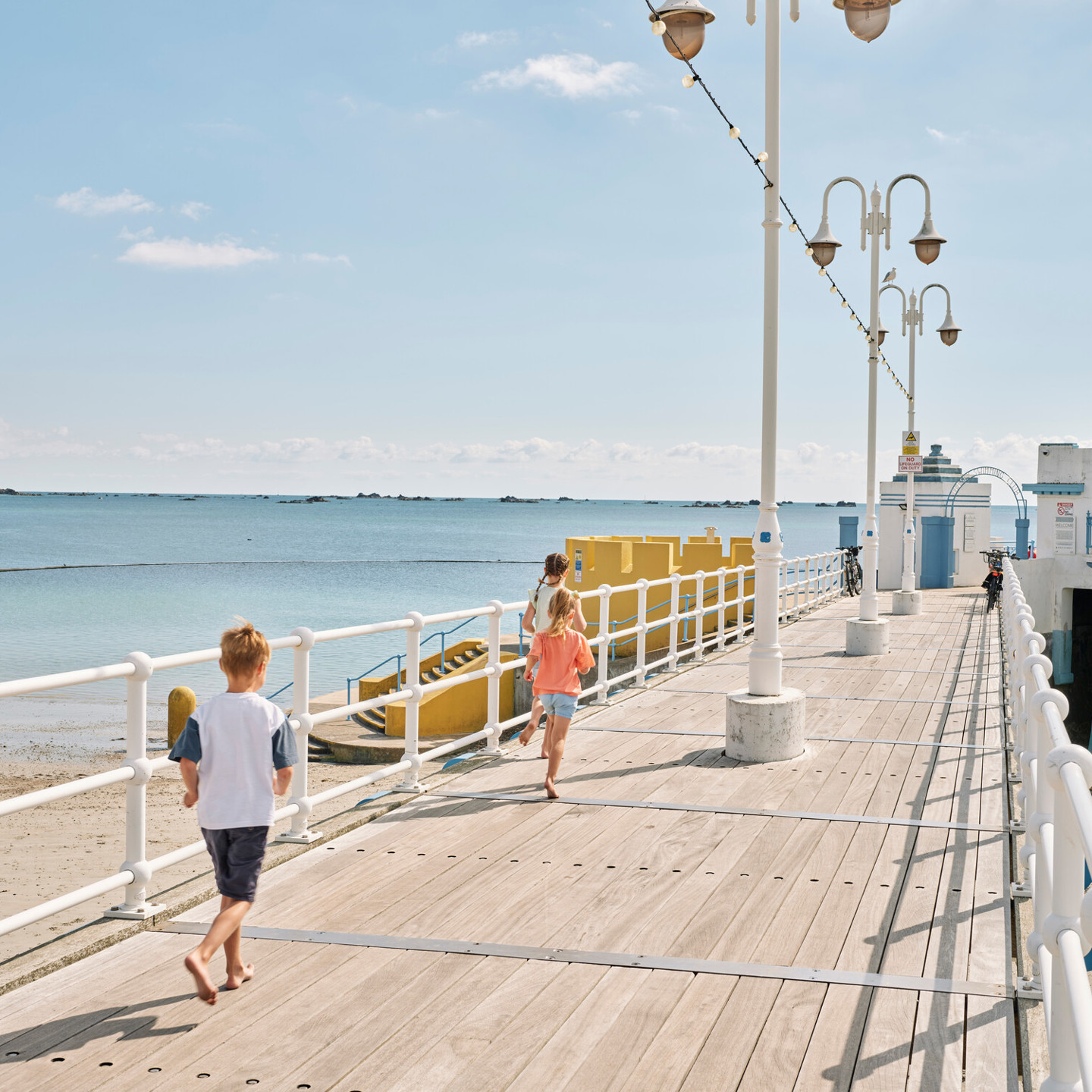 Kids running along the pier