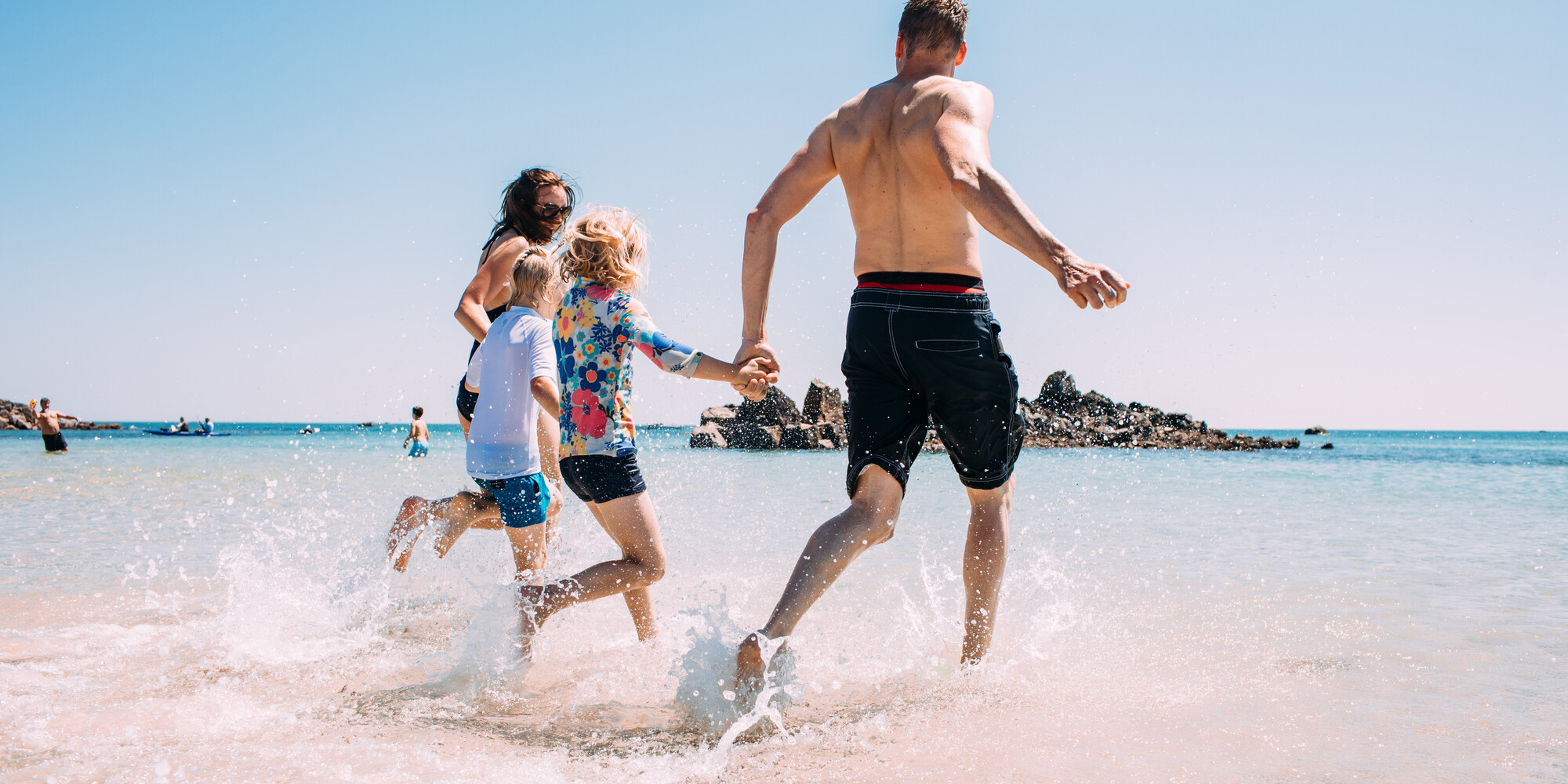 Family running into water