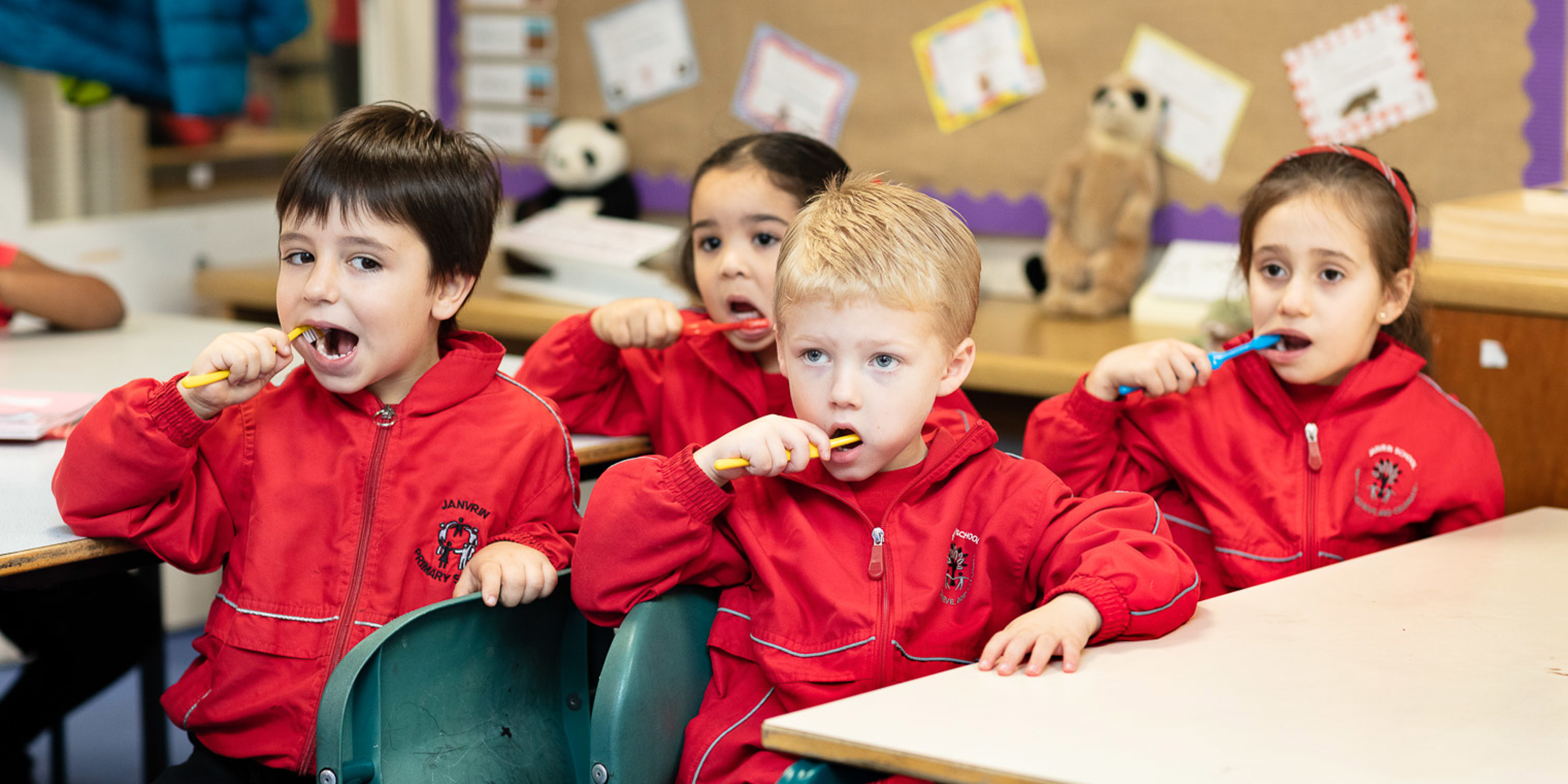 Young children brushing teeth in school