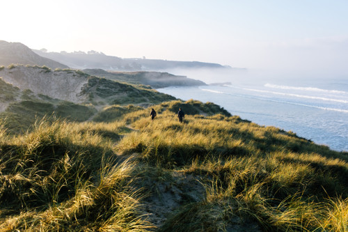 Couple walking along the coast of the sand dunes