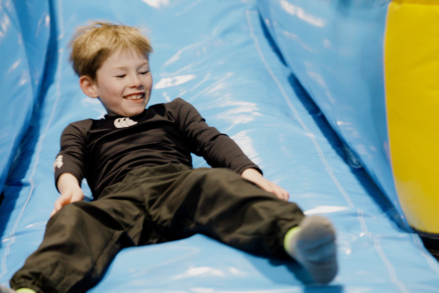 Boy going down slide inflatable arena